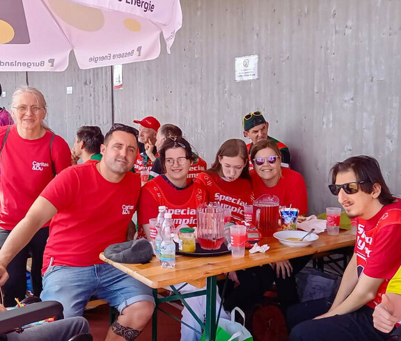 Das Haus St. Stephan nahm an den Special Olympics teil. Sie sitzen an einen Tisch herum und genießen eine Pause. 