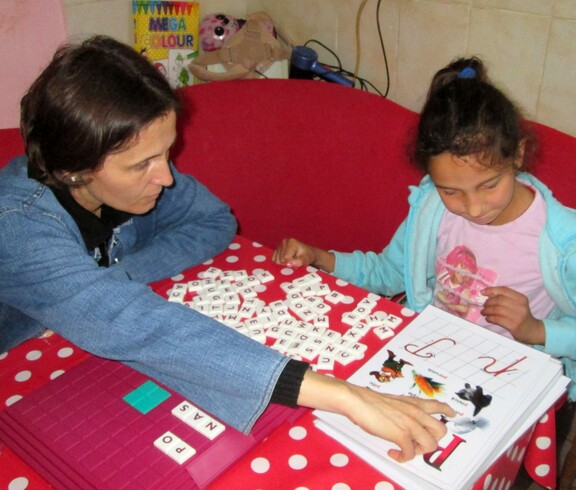 Eine Caritas Betreuerin mit Melisa, einem von rund 90 betreuten Kindern mit Behinderung in Blaj, bei der Sprachtherapie.