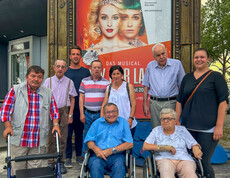 Bewohner*innen und Betreuer*innen des Haus St. Stephan waren zu Besuch bei dem Musical "My fair lady". Sie stehen gemeinsam vor den Musicalplakat