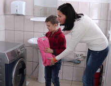 Cristina und ihre Betreuerin beim Waschen im Waschraum des Caritas Kinderzentrums in Cenade Rumänien